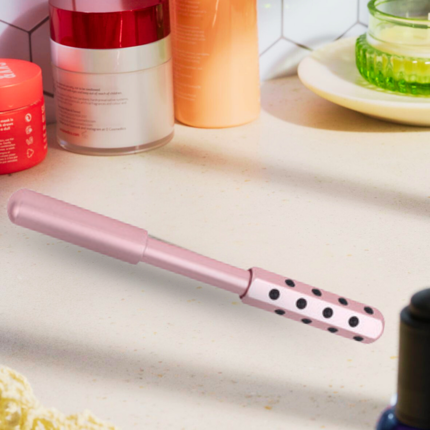 Pink germanium face roller resting on a clean white table with a minimalist decor, ideal for natural anti-aging facial massage and skin care.