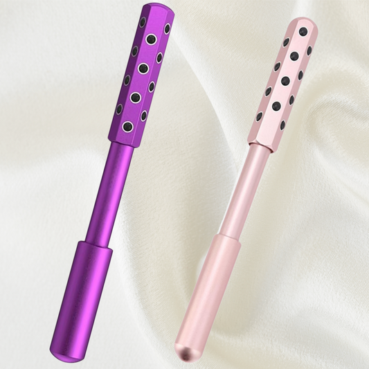 Two germanium face rollers standing upright, in purple and pink, anti-aging beauty tools for facial care
